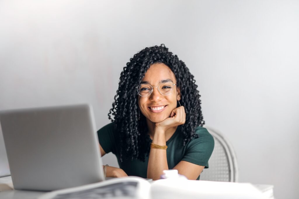 Woman smiling at desk behind laptop
